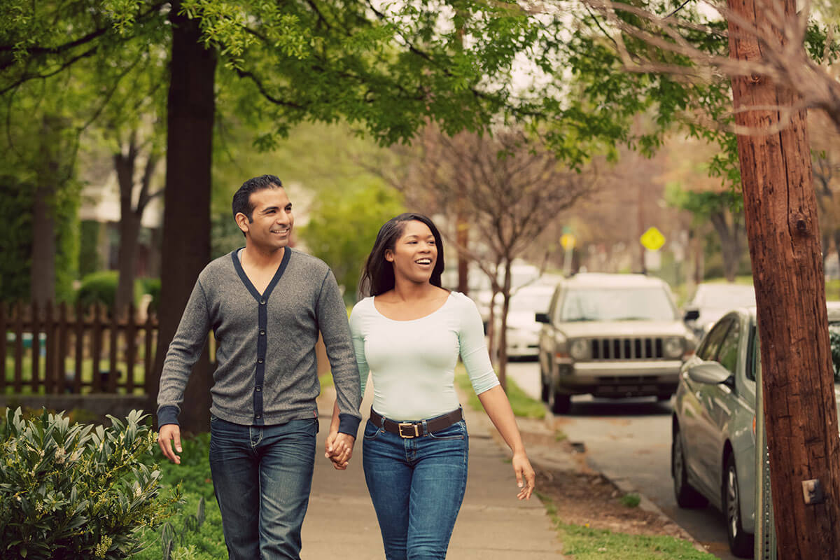 Residents walking through a quiet, tree-lined neighborhood near the community